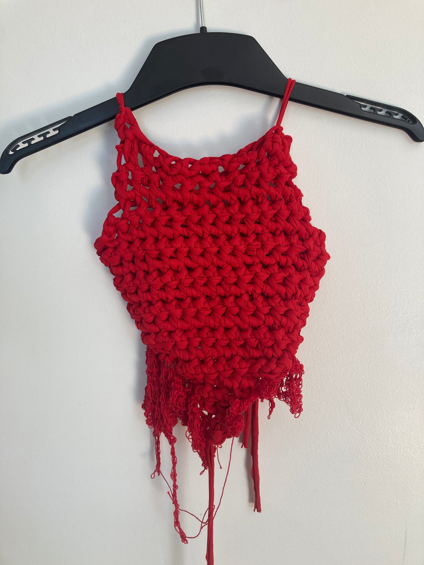 Red knitted bow with a black archery bow on a white background